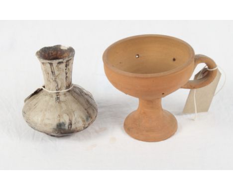 A Near Eastern black decorated waisted vase, a terracotta strainer on circular foot, a Roman terracotta tiled fragment, a sim