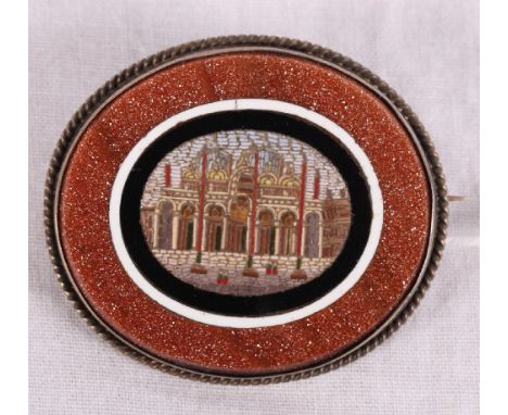 A 19th Century oval micro mosaic panel decorated view of St Mark's Square with black, white and goldstone border and gilt met