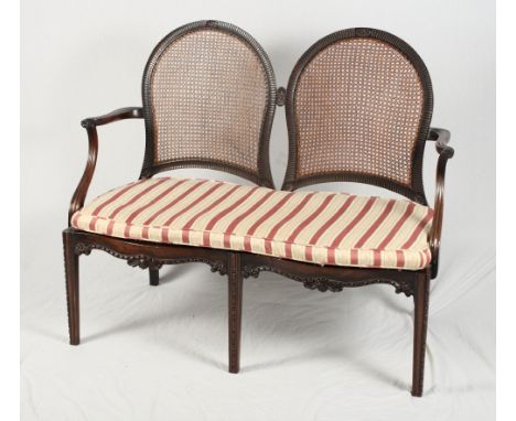 A Sheraton design mahogany two-seat settee with caned panel back and a pair of matching elbow chairs, on carved chamfered sup