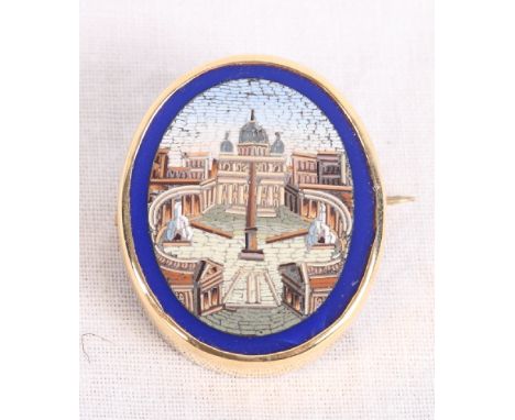 A 19th Century oval micro mosaic panel decorated view of St Peter's Square with blue border and gold brooch mount