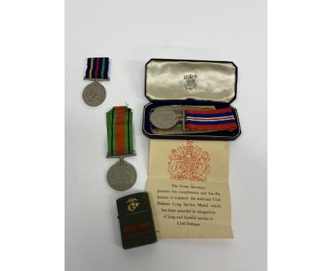 A U.S. Marine Corps flick lighter in green, 5cm H, a World War II Civil Defence medal and two others