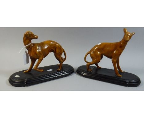 A Pair of Ceramic Hounds on Oval Plinths 