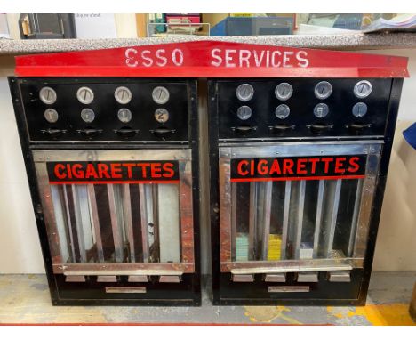 A cigarette two piece vending machine, surmounted by a one-piece pediment, overall 47 1/2" w x 39" h x 5" d.