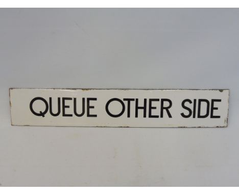 A narrow enamel sign bearing the words 'Queue Other Side', possibly railway or bus related, 15 x 2 3/4".