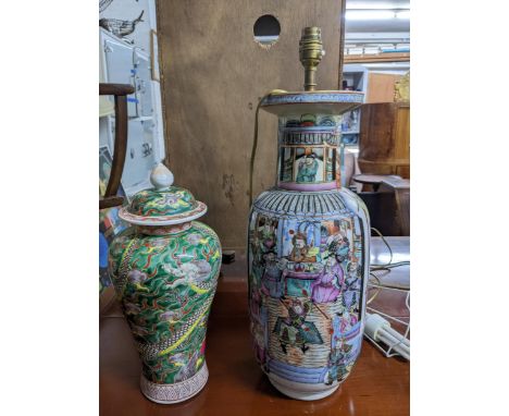 An early 20th century Chinese porcelain vase, adapted to a table lamp, decorated with warriors at play in a mountainous lands