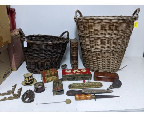 Two wicker baskets containing various vintage tins, one in the form of a top hat, a wooden handled dagger with a red painted 