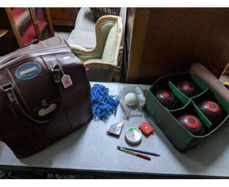 A vintage leather holdall bag containing a sets of four Hemselite super grip championship lawn bowls, BIBC official 65Locatio