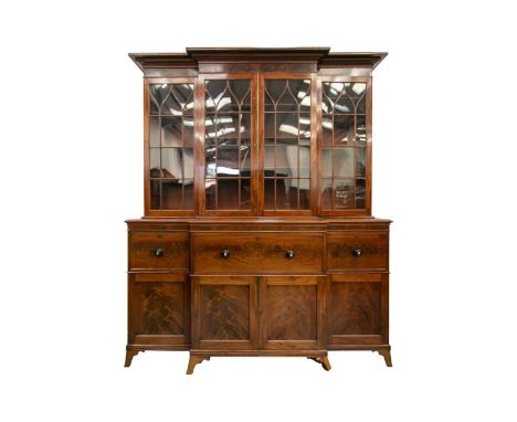 A large early 19th century figured mahogany break-front secretaire library bookcase; the upper section with four elliptical g