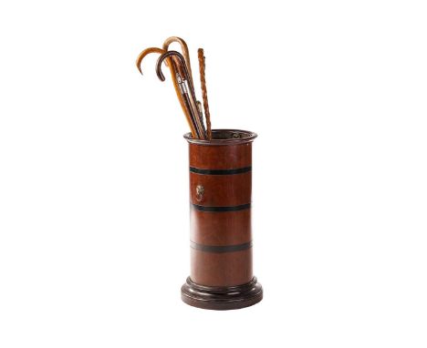 An Edwardian-turned mahogany cylindrical stick stand with moulded rim and foot, the body with contrasting ebonized bands and 