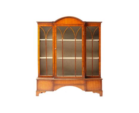 An early 20th-century mahogany miniature single-door breakfront bookcase with a domed central section; supported by shaped br