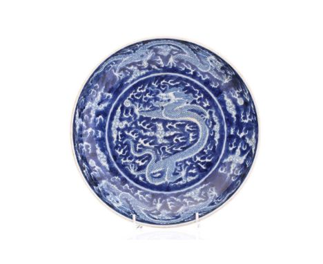 A Chinese porcel;ain blue &amp; white dragon dish, painted with a central dragon bordered by two further dragons, all amongst