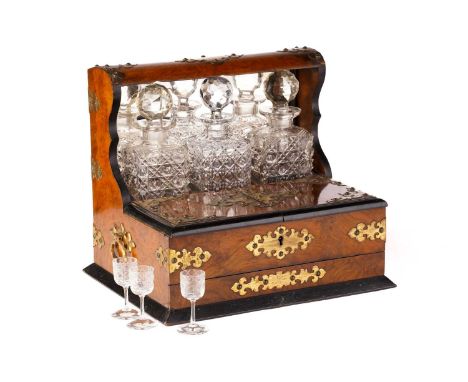 A Victorian walnut and gilt-metal mounted three decanter tantalus and games compendium, the square decanters over a hinged co