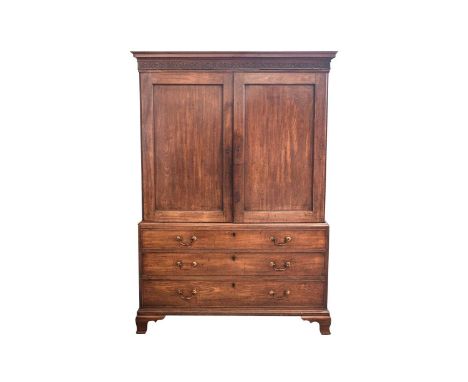 A George III mahogany linen press, the two-door upper section with blind fret frieze, the figured panel doors opening to reve