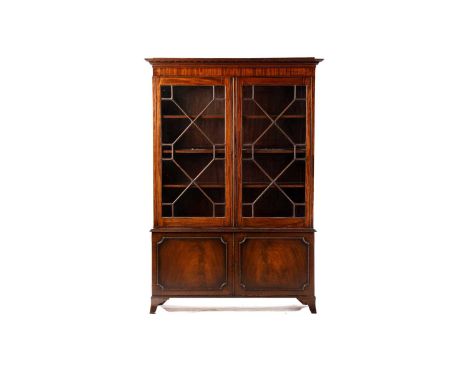 George III mahogany bookcase, on a later stand, the protruding dentil cornice over a pair of astrgal glazed doors, enclsoing 