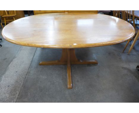 An Ercol elm and beech pedestal dining table 