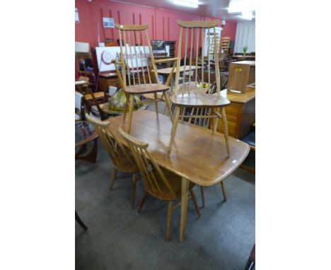 An Ercol Blonde elm and beech plank dining table and six Goldsmith chairs 