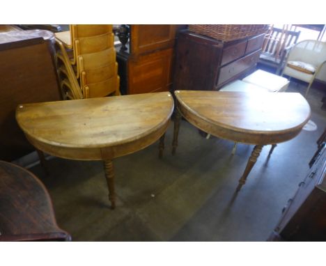 A pair of French pine demi lune console tables 