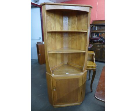 An Ercol Blonde elm and beech freestanding corner cabinet 