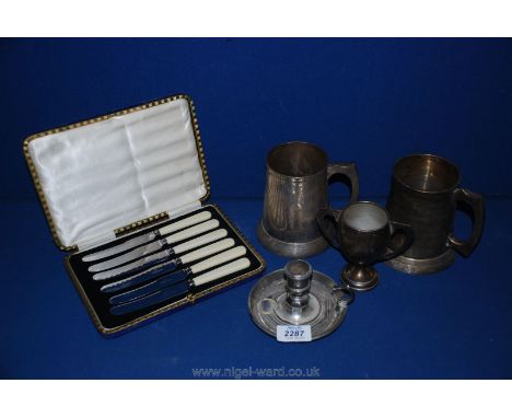 A cased set of tea Knives, two plated tankards and a plated chamber stick.