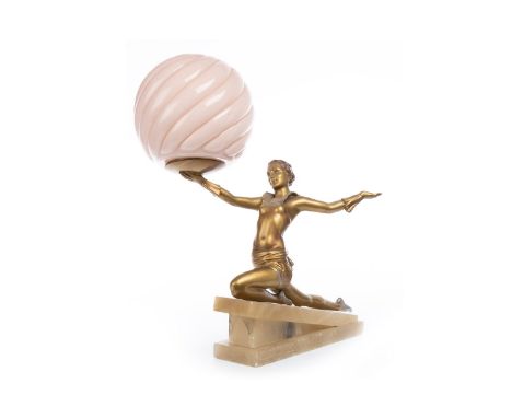 MANNER OF LORENZL, A GILDED SPELTER TABLE LAMP IN THE FORM OF A KNEELING ACROBAT, her right hand held aloft supporting a pink