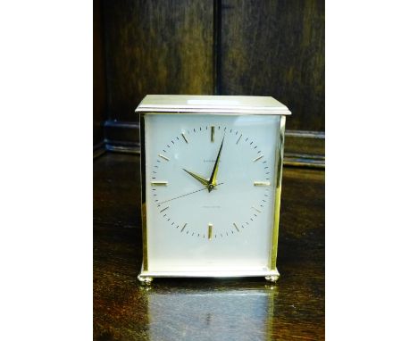 A Garrard brass cased clock, the silvered dial with brass hour batons, on bun feet, 14cm high