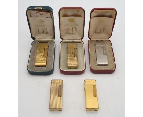 Five various Dunhill "Rollagas" lighters, including gold-plated examples, three being boxed, two with initials engraved to li