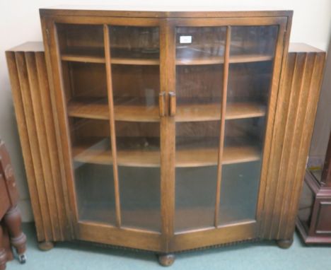 An early 20th century Art Deco glazed two door bookcase with open bookcase ends, 112cm high x 122cm wide x 36cm deep Conditio