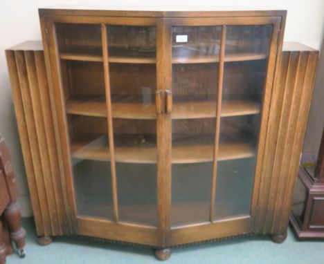 An early 20th century Art Deco glazed two door bookcase with open bookcase ends, 112cm high x 122cm wide x 36cm deep Conditio