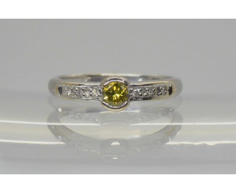 An 18ct white gold yellow diamond ring of estimated approx 0.20cts with further diamond accents to the shoulders, finger size