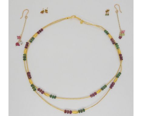 An Eastern style two strand yellow metal necklace with cut emerald and ruby beads and yellow metal spacers, marked 375, toget