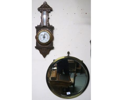 A 20th century carved oak barometer/thermometer and brass framed circular wall mirror (2) Condition Report:Available upon req