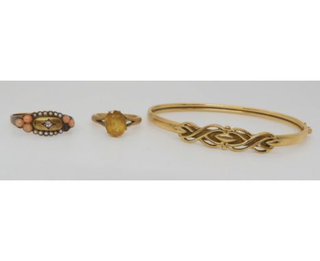 A 15ct coral, seed pearl and diamond set ring, a 9ct citrine set ring, and a 9ct gold bangle Condition Report:Available upon 