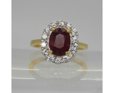 An 18ct gold ruby and diamond cluster ring, set with a 8.8mm x 6.6 x 3.7mm, ruby, surrounded with estimated approx 0.40cts of