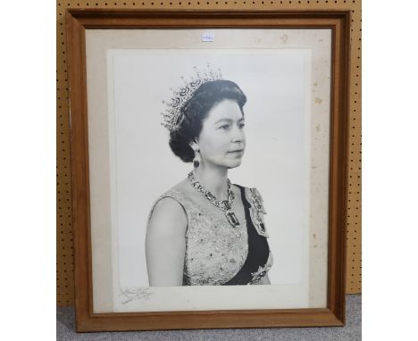 A framed photographic portrait of Queen Elizabeth II by Anthony Buckley, signed by the photographer bottom left corner, frame