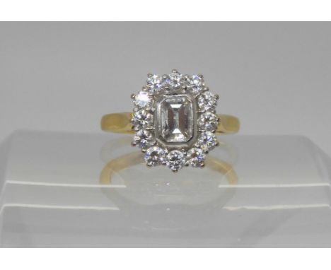 An 18ct gold diamond cluster ring set with an estimated approx 0.53cts step cut diamond, surrounded with a further 0.60cts of