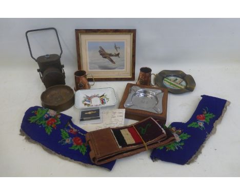 An assortment of military and other items including a WWII bicycle lamp and an ashtray.