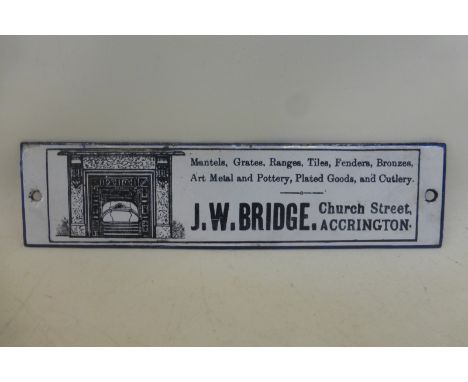 A small, narrow black and white enamel strip advertising J.W. Bridge, Church Street, Accrington who produced mantles, grates,