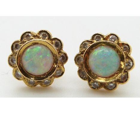 A pair of 18ct gold earrings set with an opal cabochon surrounded by diamonds&nbsp;