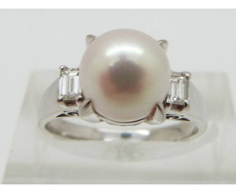 A platinum ring set with a pearl and with an emerald cut diamond to each shoulder, total diamond weight approximately 0.23ct,