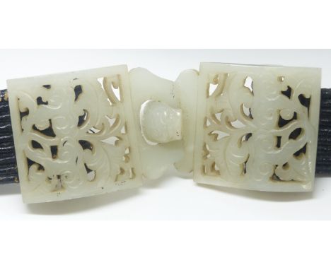 A 19th Century Chinese pierced and carved jade belt buckle in two parts, on later belt, 4.5 x 11 cm.&nbsp;&nbsp;