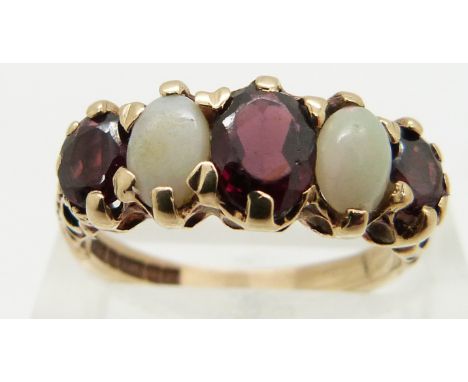 A 9ct gold ring set with oval cut garnets and opal cabochons, size N