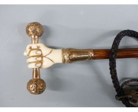 Victorian parasol, the handle an 18ct gold plated and ivory fist holding a bar, with yellow metal suspension loop, on hardwoo