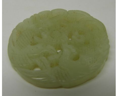 A Chinese carved and pierced jade plaque with bird and foliage decoration, diameter 5cm&nbsp;
