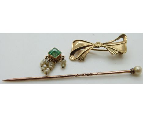 A 9ct gold bow brooch, an emerald and seed pearl charm and a stick pin set with a pearl&nbsp;