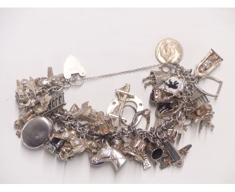 A vintage hallmarked silver and white metal charm bracelet including approximately 40 charms