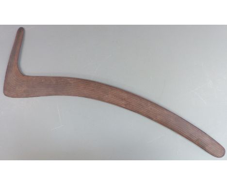 A 19thC Australian Aboriginal hunting boomerang or throwing stick with carved parallel lines and adzed verso, length 78cm