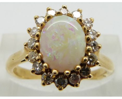 An 18ct gold ring set with an opal cabochon and diamonds, size N