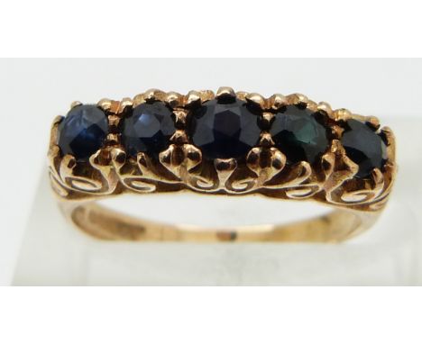 A 9ct gold ring set with five round cut sapphires, size K