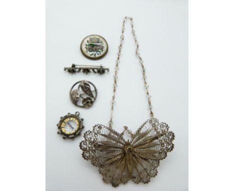 A filigree brooch in the form of a butterfly, silver brooch set with seed pearls, a reverse painted mother of pearl brooch, s