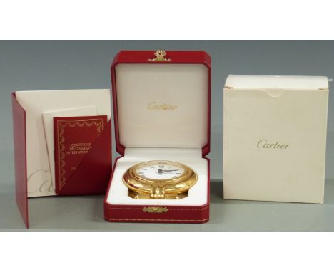 A Cartier desk alarm clock in original case and box. Brass case with folding stand, Roman dial, the winder and stop buttons w